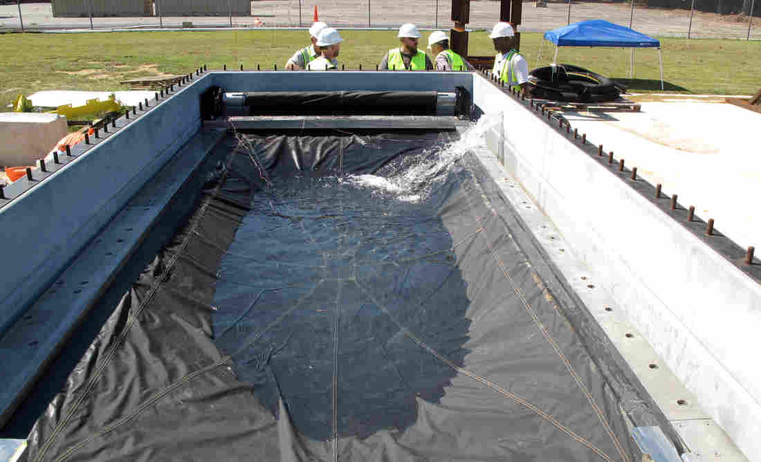 Engineers test the Flex-Gate, a big sheet of waterproof fabric designed to cover subway entrances and keep water out. Its creation was inspired in part by roll-up metal doors used to cover store entrances. Joel Rose/NPR 