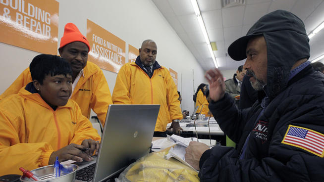 Michael Barretto, right, whose home was flooded and damaged in Sandy, applies for assistance at an NYC Restore location in Far Rockaway.