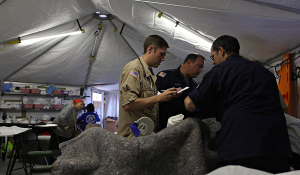 Dr. Aaron Gardener, center, attended to a patient at an ad hoc medical unit in Long Beach, N.Y. Many people have coughs, rashes and other ailments. 